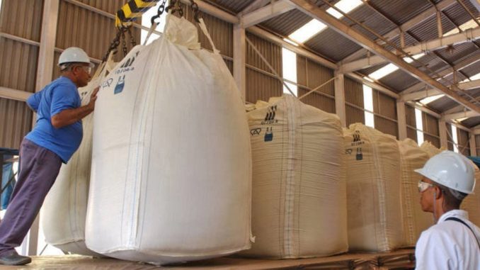FAO / Giuseppe Bizzarri Trabalhadores carregam cana-de-açúcar em uma destilaria de etanol no Brasil.