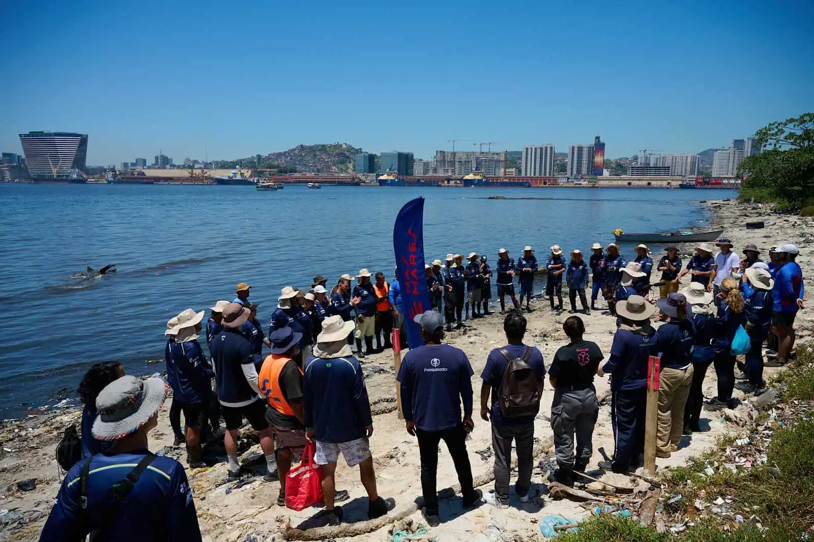 Sem desanimar diante das altas temperaturas, cerca de 50 pessoas entre voluntários e pescadores contratados, diretamente impactados pela poluição da Baía de Guanabara, se uniram ao mutirão - crédito: AT Films